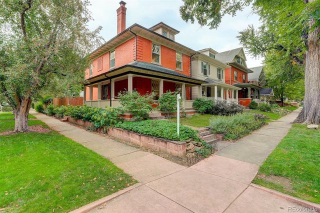 a front view of a house with a yard and potted plants