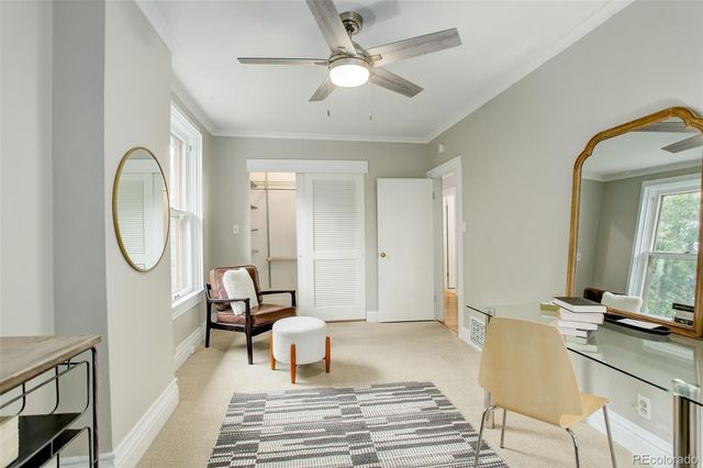 a living room with furniture a mirror and a chandelier fan