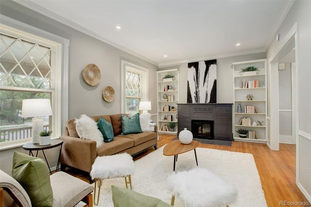 a living room with furniture a fireplace and a large window