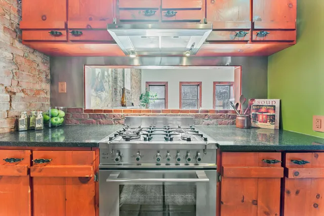 a kitchen with stainless steel appliances granite countertop a stove and cabinets