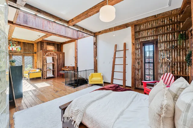 a bedroom with a bed couch and a large window