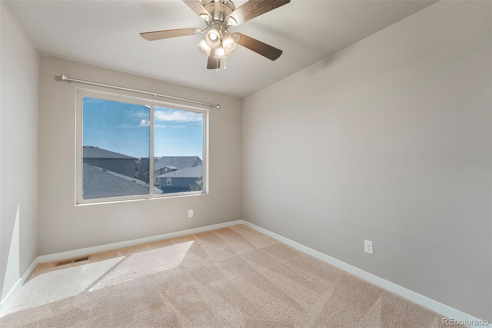 9528 Timberlake Loop Colorado Springs, CO 80927 - Photo 27 of 37 an empty room with a chandelier fan and windows
