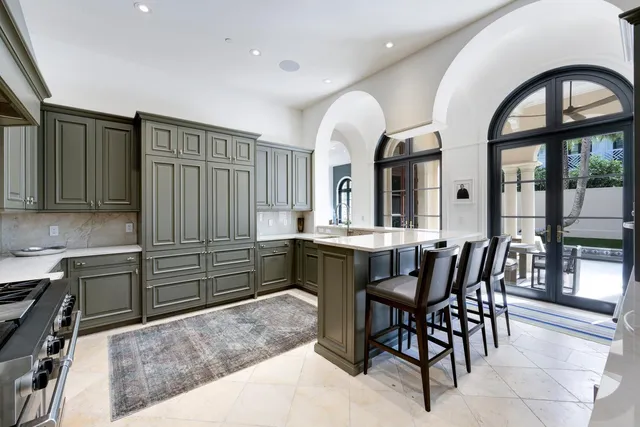 a kitchen with stainless steel appliances kitchen island granite countertop a table chairs and a sink