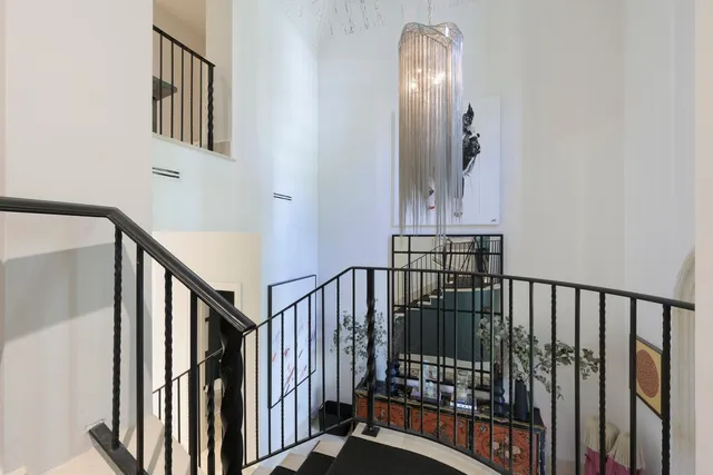 a view of staircase with railing and a chandelier