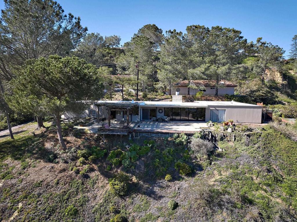 a backyard of a house with a garden and outdoor seating
