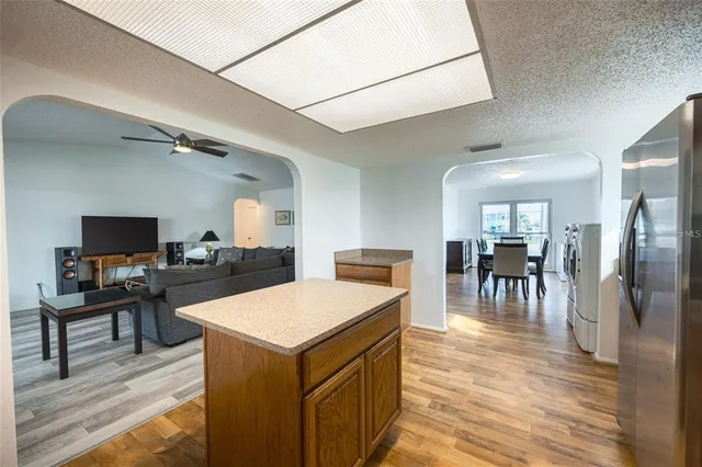 a large kitchen with a table chairs refrigerator and a table