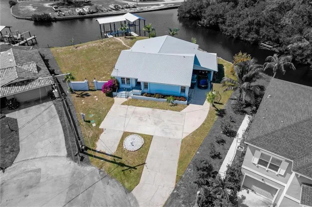 an aerial view of a house with pool and chairs