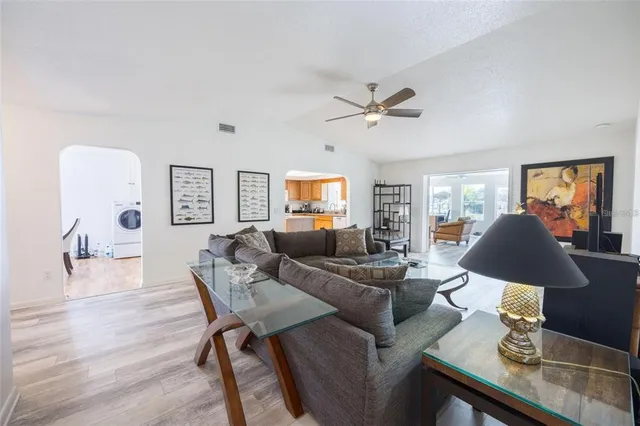a living room with furniture kitchen view and a window