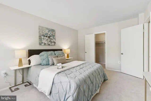 a bedroom with a bed and a lamp on dresser