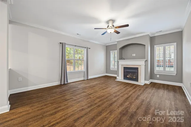 a view of empty room with wooden floor and fireplace