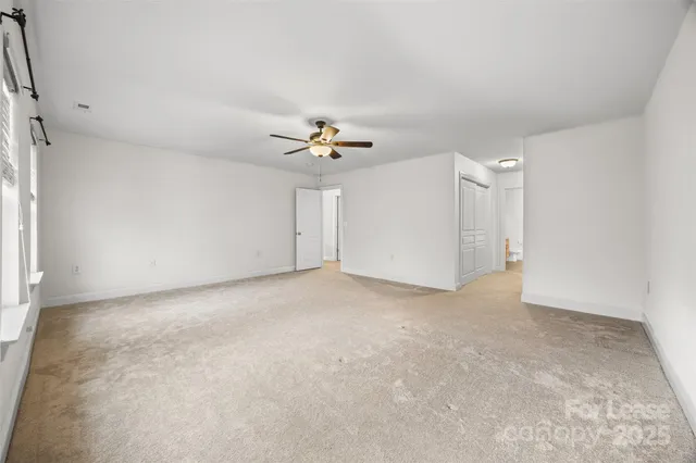 a view of a livingroom with a ceiling fan and kitchen view