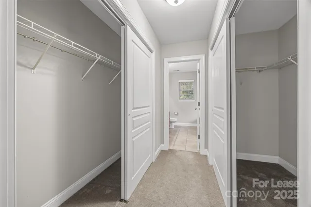 a bathroom with double vanity sinks a toilet a mirror and a window