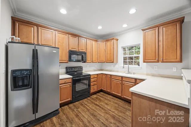 a kitchen with stainless steel appliances granite countertop a refrigerator stove microwave and sink
