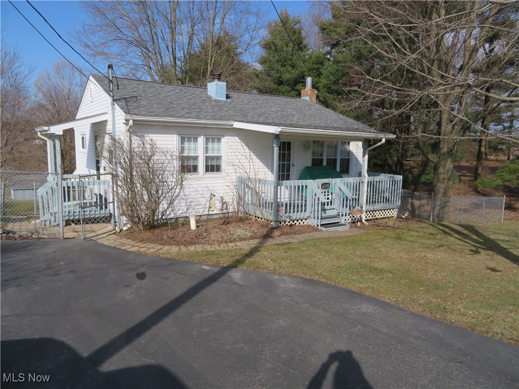 4358 Buss Road Wooster, OH 44691 - Photo 24 of 24 View of front of house with a chimney, a shingled roof, covered porch, fence, and a front lawn