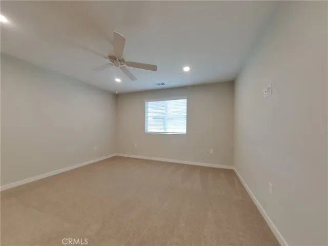 an empty room with a window and a fan