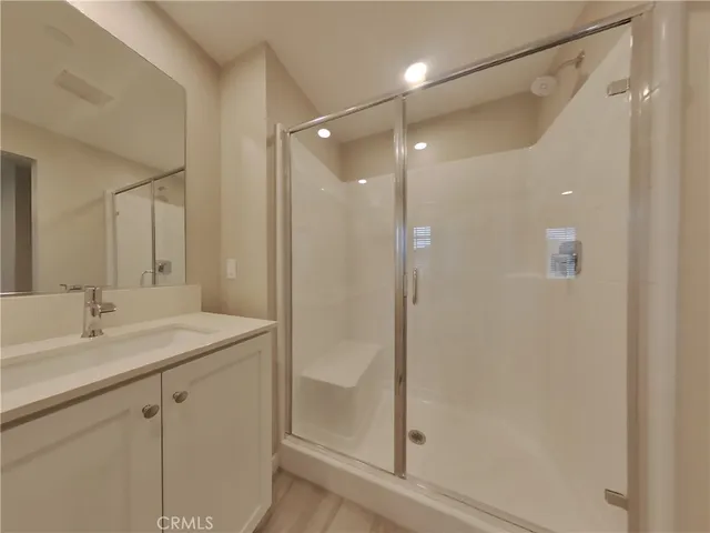 a bathroom with a shower sink vanity and mirror