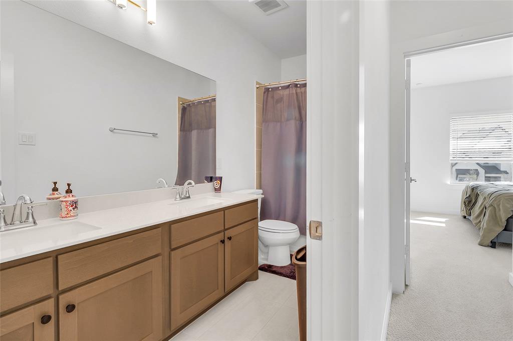 1241 Lupine Road Prosper, TX 75078 - Photo 29 of 38 Bathroom featuring a dual vanity with light-colored countertops, wood-finish cabinetry, and integrated sinks