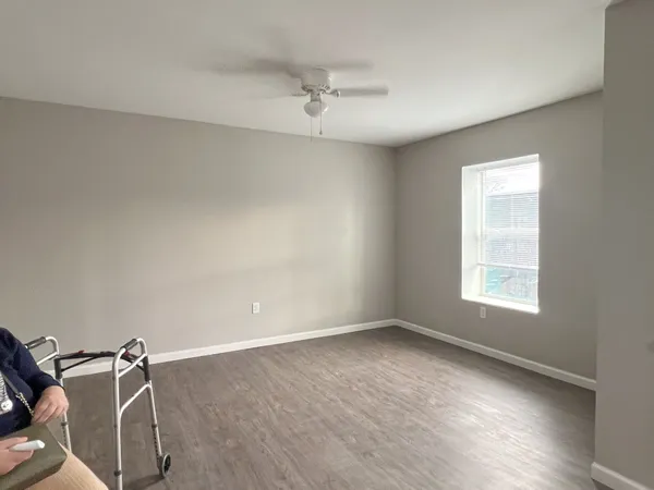 an empty room with a window and a ceiling fan