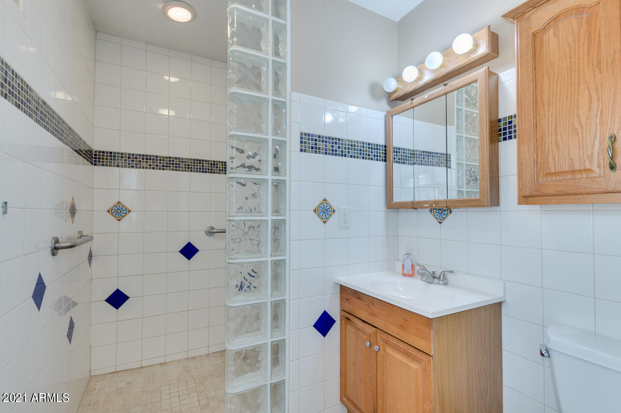 4215 West Dailey Street Phoenix, AZ 85053 - Photo 19 of 32 a bathroom with a shower sink and mirror