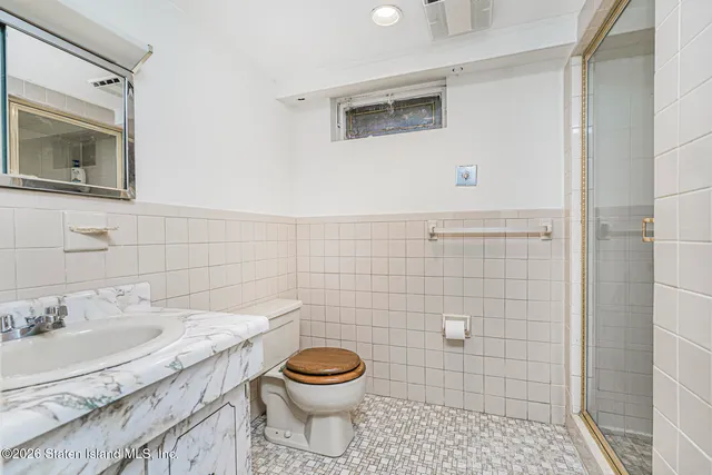 a bathroom with a granite countertop toilet sink and mirror