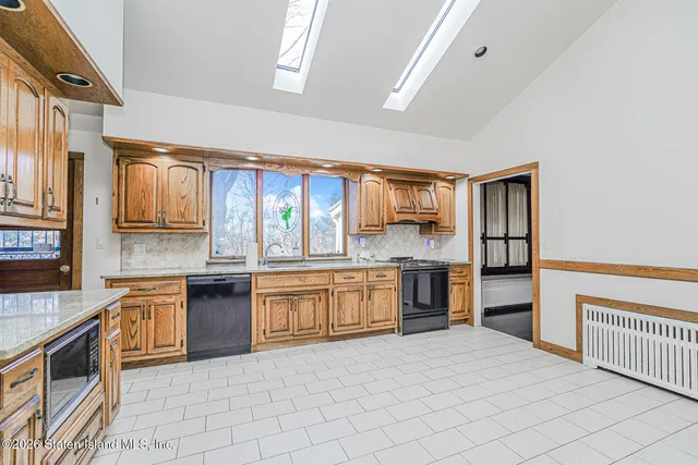 a large kitchen with stainless steel appliances granite countertop a stove top oven a sink dishwasher and granite countertops
