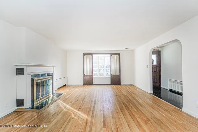 a view of empty room with wooden floor and fireplace