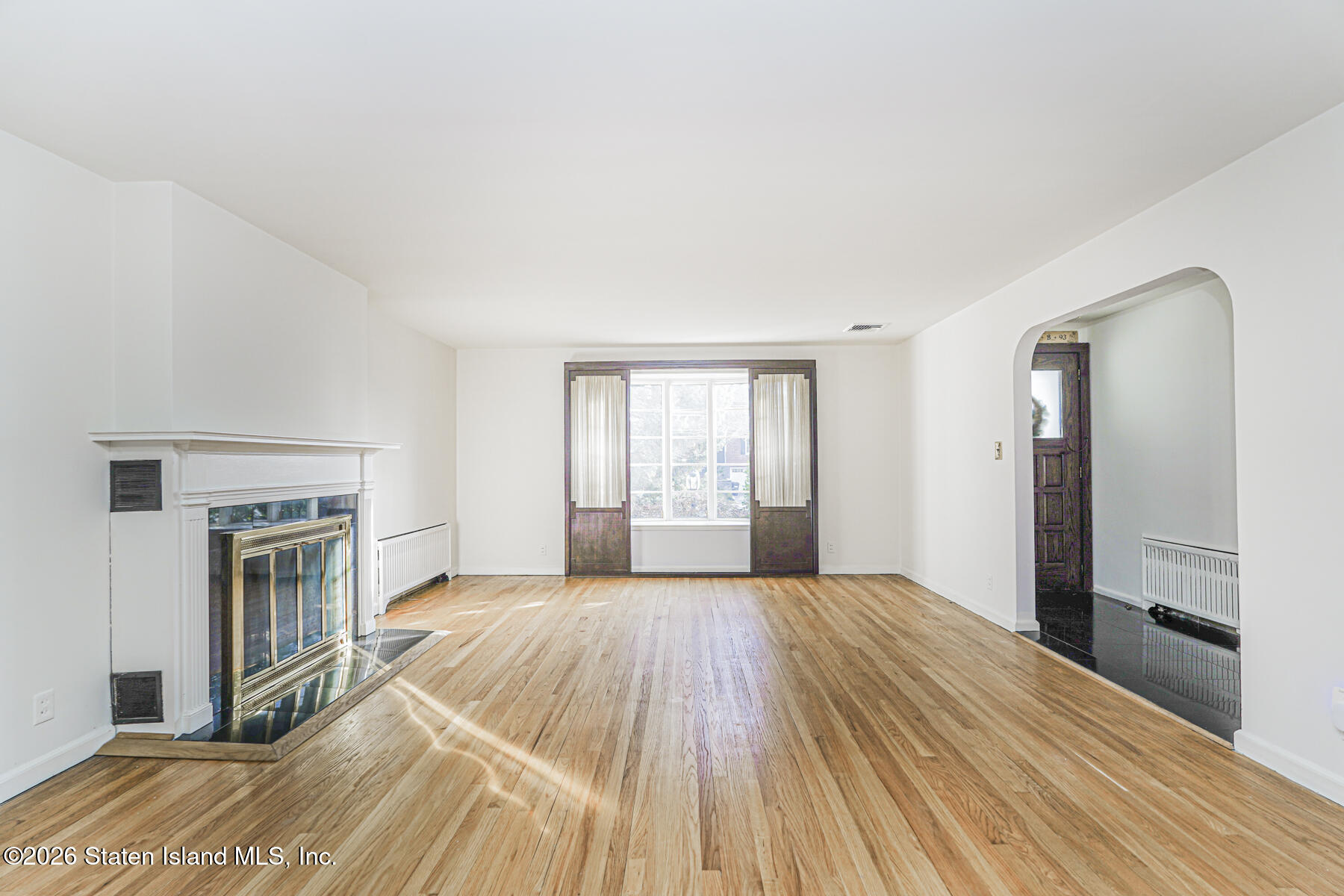 35 Rice Avenue Staten Island, NY 10301 - Photo 7 of 33 a view of empty room with wooden floor and fireplace