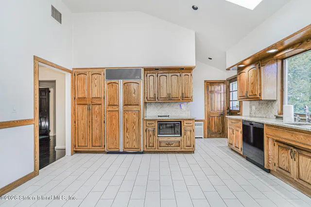 a kitchen with granite countertop a refrigerator stove top oven and sink