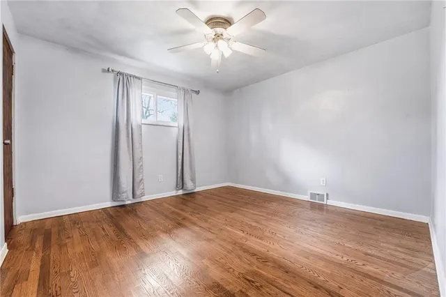a view of a room with wooden floor and a ceiling fan