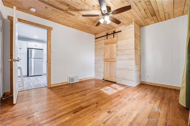 en empty room with wooden floor and ceiling fan