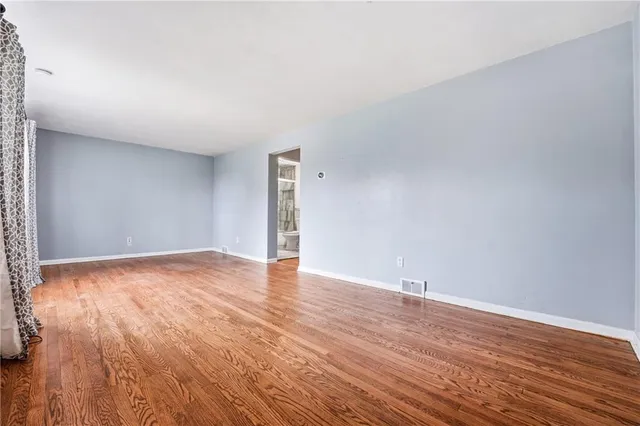 a view of an empty room and wooden floor