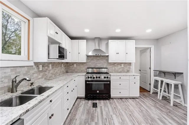 a kitchen with stainless steel appliances granite countertop a stove a sink and a refrigerator