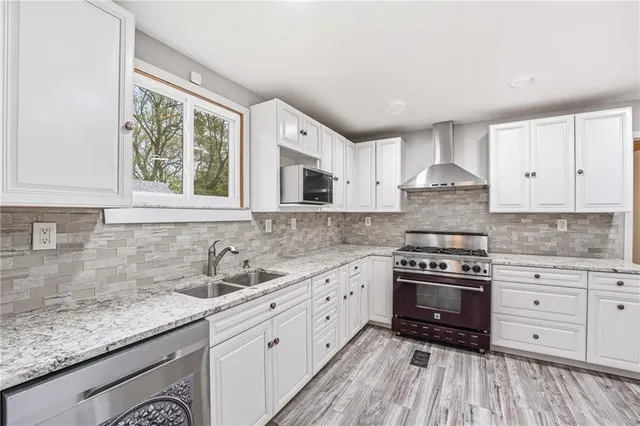 a kitchen with granite countertop a sink cabinets stainless steel appliances and a counter space