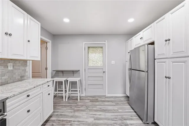 a large white kitchen with a refrigerator and a sink