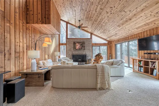 a living room with fireplace furniture and a large window