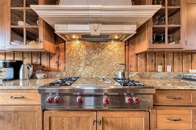 a kitchen with stainless steel appliances granite countertop a stove and a white cabinets