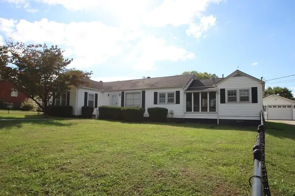 a front view of a house with a garden and yard
