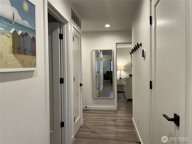 a view of a hallway with wooden floor and staircase