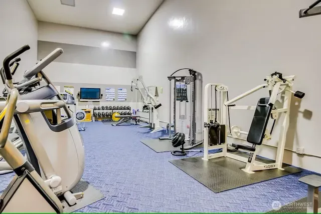 a swimming pool with lawn chairs and large trees