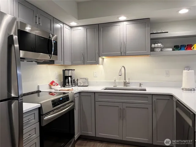 a kitchen with a sink cabinets and stainless steel appliances