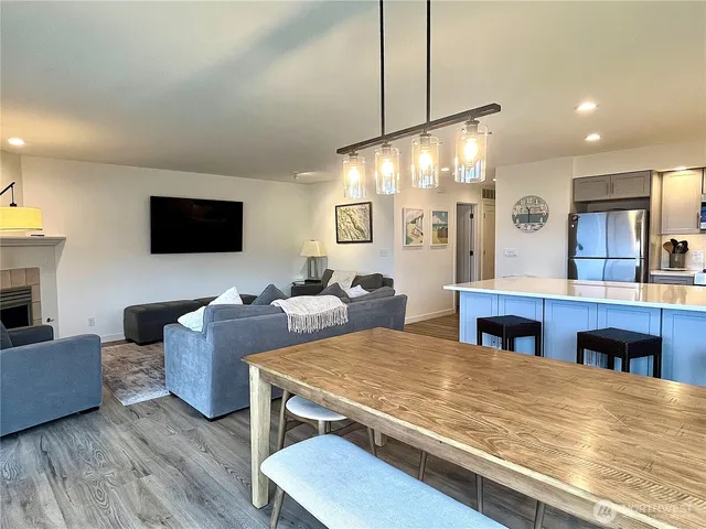 a living room with furniture flat screen tv and kitchen view