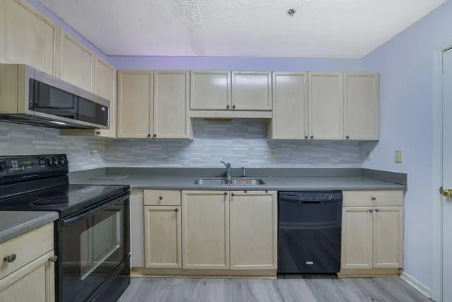a kitchen with stainless steel appliances granite countertop a sink and a stove top oven
