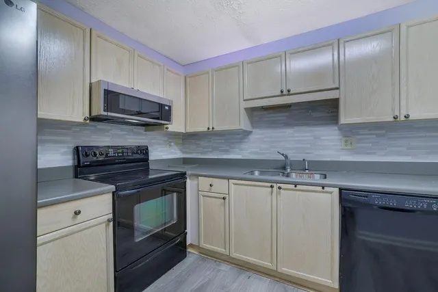 a kitchen with cabinets stainless steel appliances and a sink