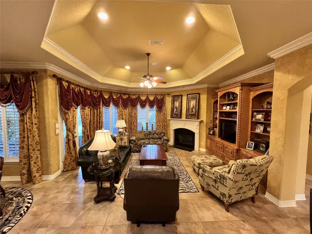a living room with fireplace furniture and a large window