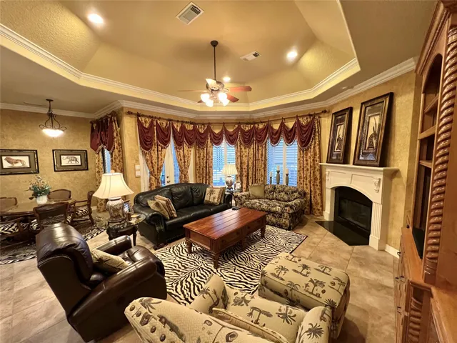 a living room with furniture a fireplace and a chandelier