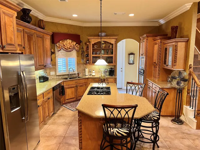 a kitchen with stainless steel appliances granite countertop a stove a sink and a refrigerator