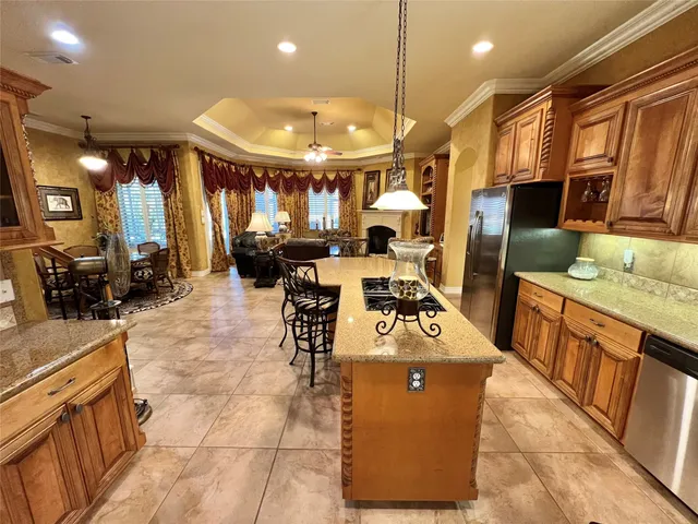a kitchen with stainless steel appliances granite countertop a stove a sink dishwasher and a refrigerator with wooden floor