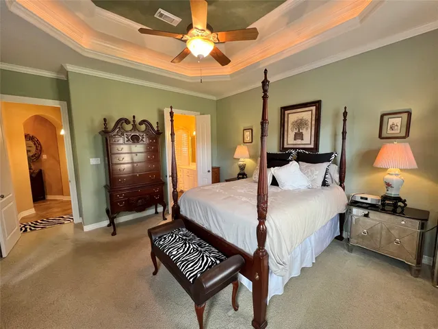 a spacious bedroom with a bed and a chandelier