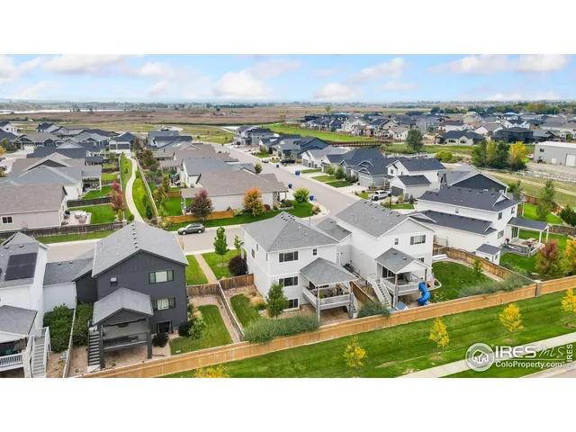 an aerial view of residential houses with outdoor space and ocean view