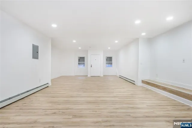 a view of empty room with wooden floor